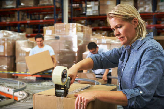 Woman Taping box in factory
